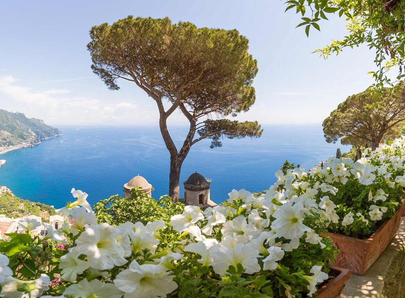 Scenic view of Amalfi Coast from Ravello terrace with white flowers and blue sea