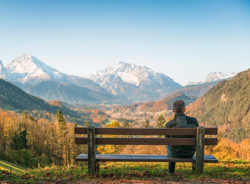 Traveller sitting on the bench enjoying the view of Watzmann mountain and Berchtesgaden town