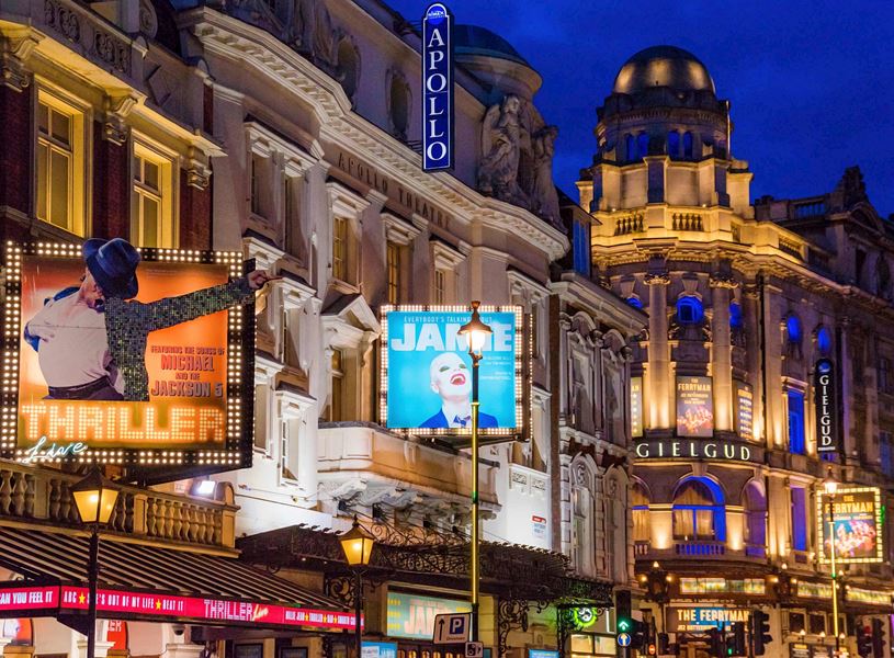West End Theatres at night with illuminated show sign in London, England