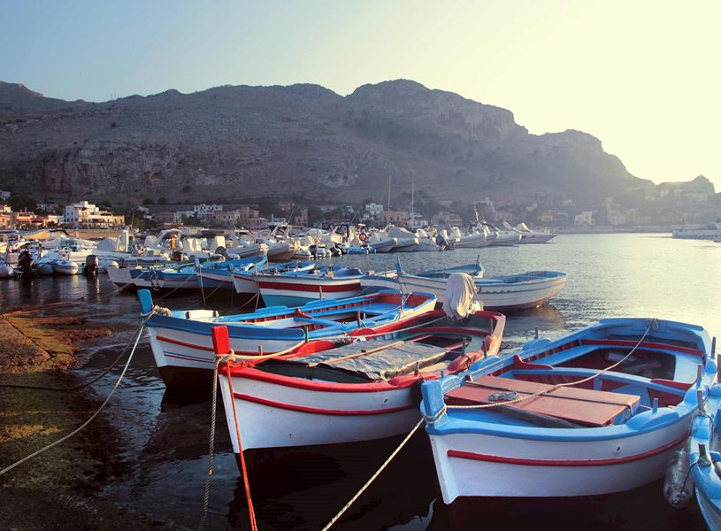 Fishing boats moored in Sferracavallo harbour and mountain backdrop