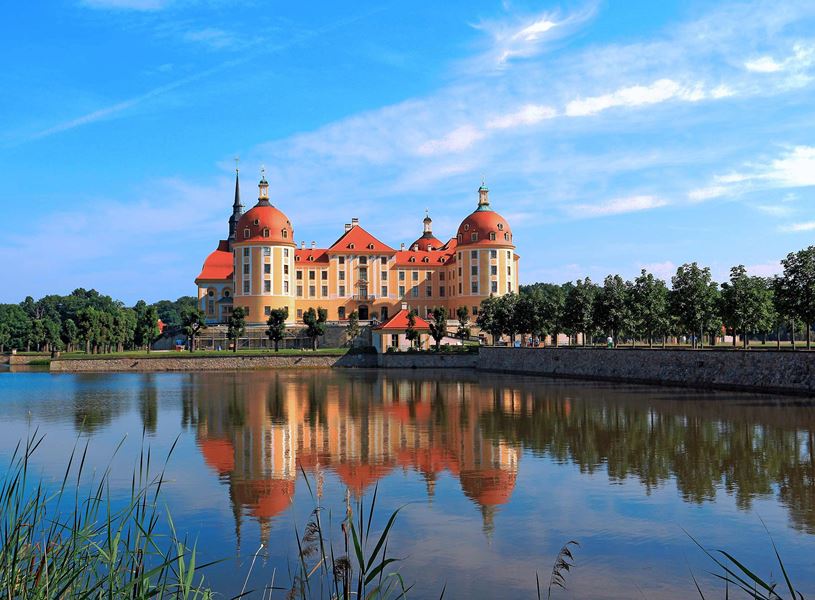 Moritzburg Castle reflected in lake under clear sky