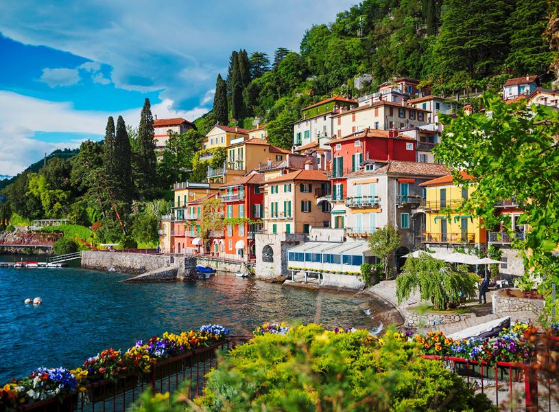 Colourful houses along Lake Como waterfront with flowers and greenery