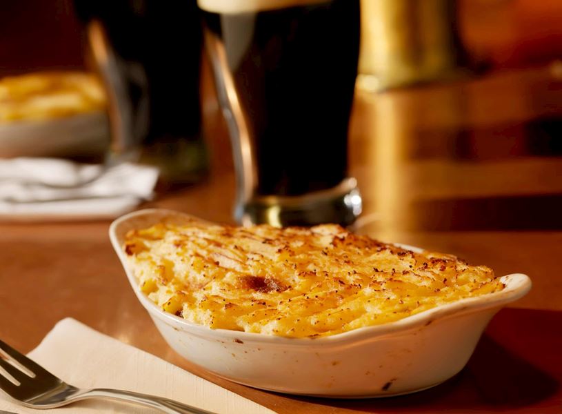 Baked shepherd’s pie with crispy mashed potato topping in ceramic dish