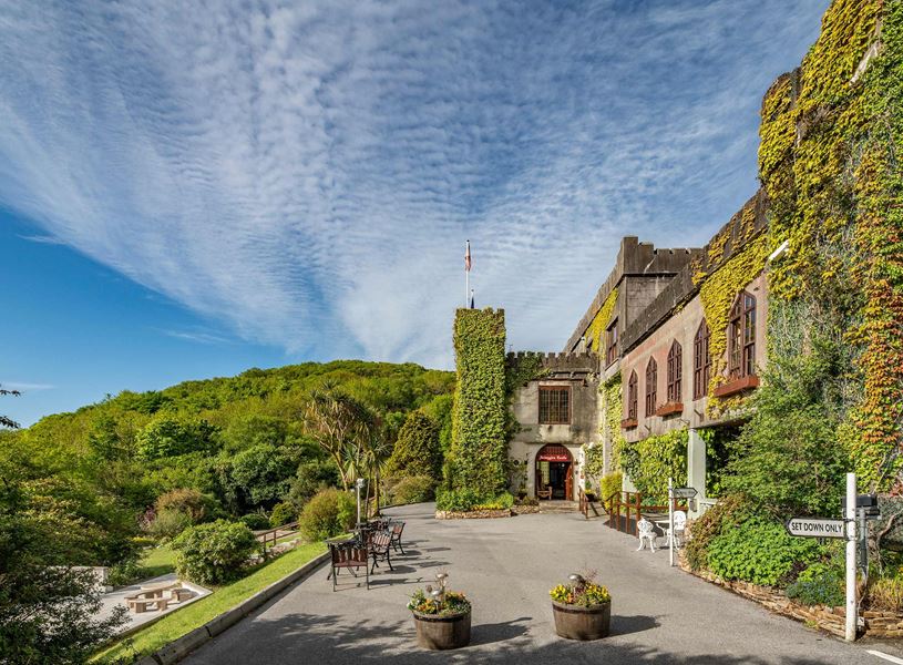 Abbeyglen Castle Hotel with ivy-covered walls and garden seating area
