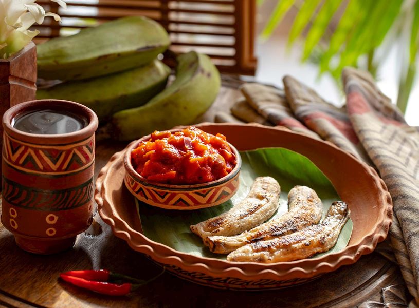 Traditionally presented Boli, sauce and grilled plantain dish, Africa