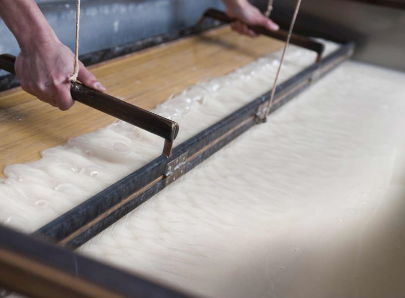 Worker producing traditional paper using machine in Gokayama, Japan
