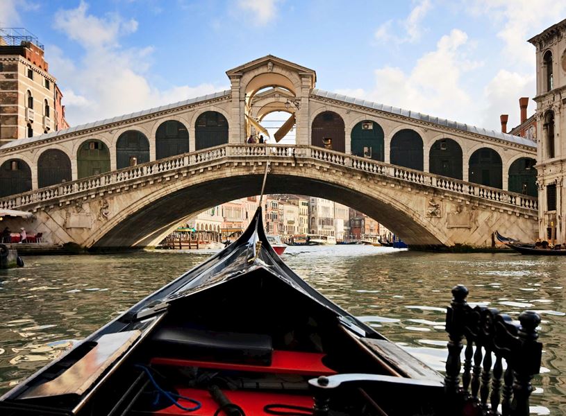 Scenic view from gondola on Grand Canal approaching Rialto Bridge in Venice, Italy