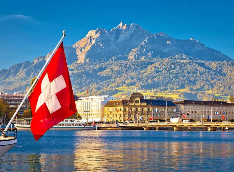 A Swiss flag waving over Pilatus Lake in Lucerne, Switzerland