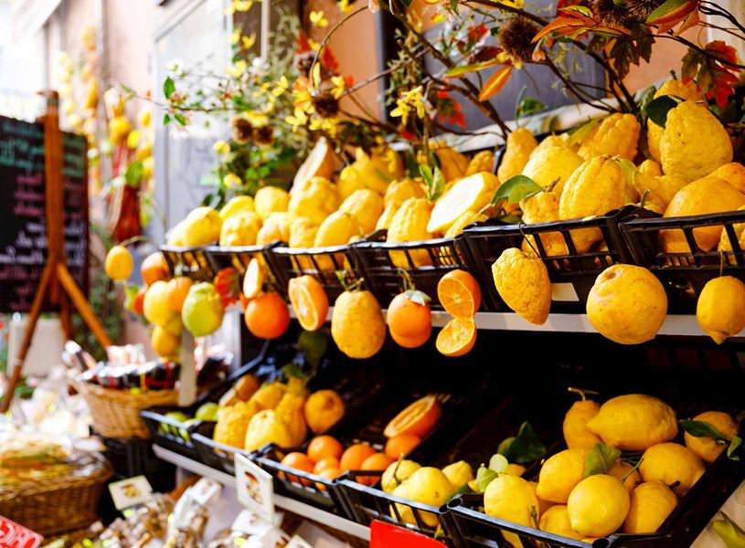 Close view of fresh lemons and citrus fruits displayed in a market stall