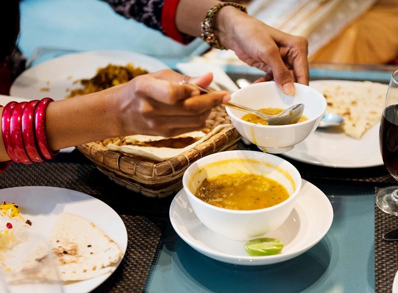 Serving freshly cooked Indian food into white plates in Jaipur, India