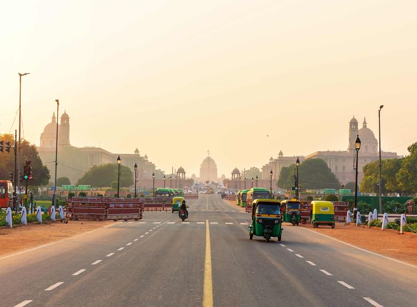 Sunset traffic with tuk-tuks near the Presidential Residence in Delhi, India
