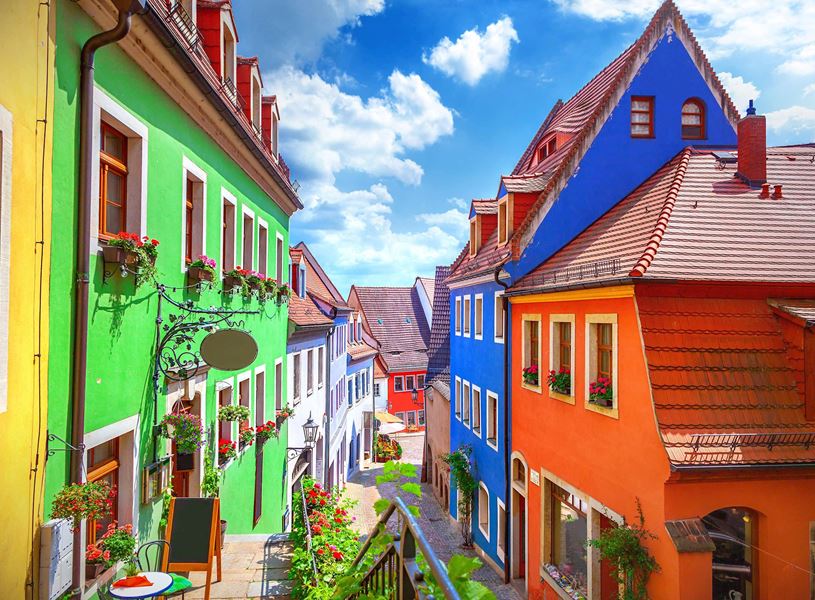 Colourful Meissen street with flower-adorned windows and cobblestone path