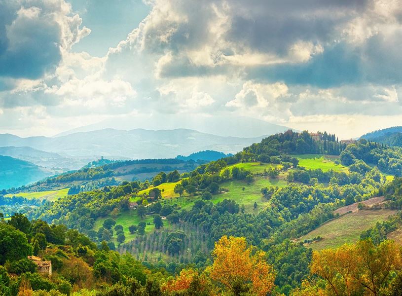 Rolling green hills of the Apennine Mountains under cloudy sky