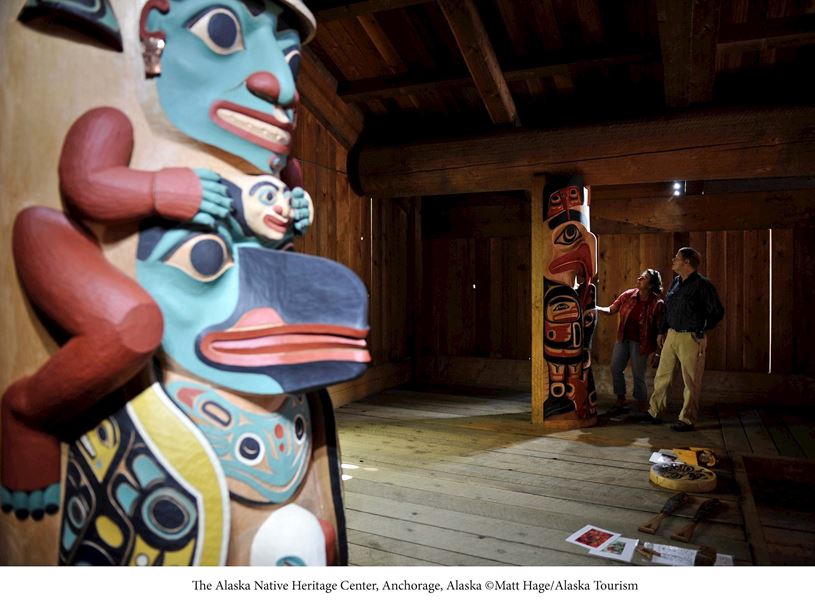 Travellers admiring the totem poles at the Native Heritage Center in Anchorage, Alaska, USA 