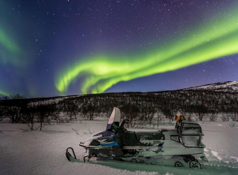 Snowmobile under Northern Lights in Ivalo, Finland
