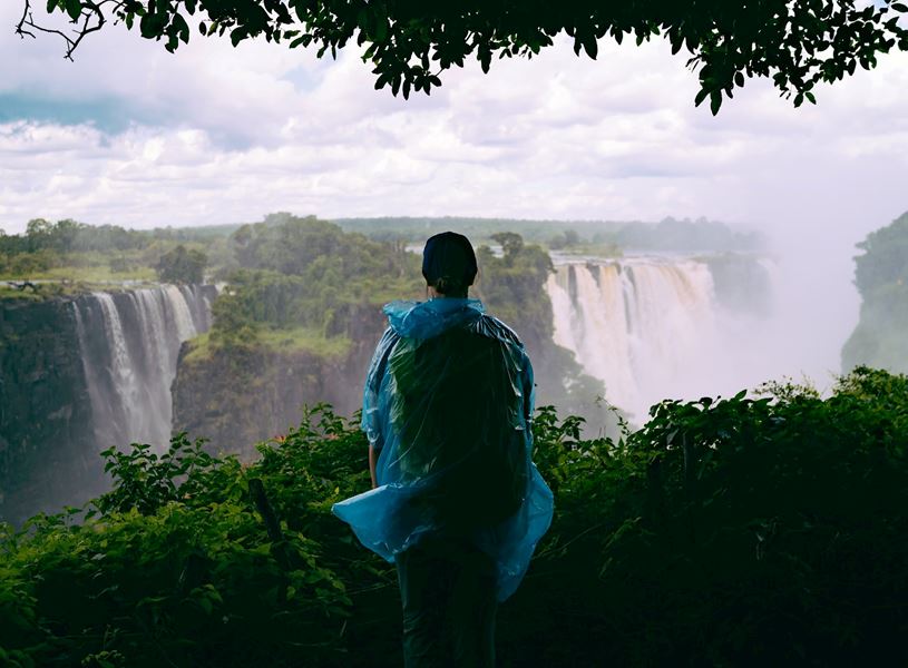 Traveller seen from behind enjoying view of Victoria Falls, Zimbabwe