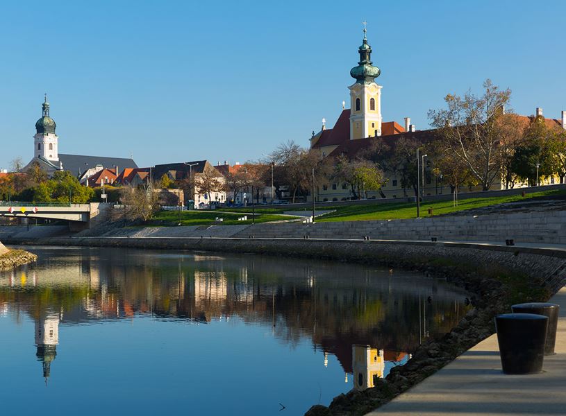 Győr cityscape with river reflections and historic church towers