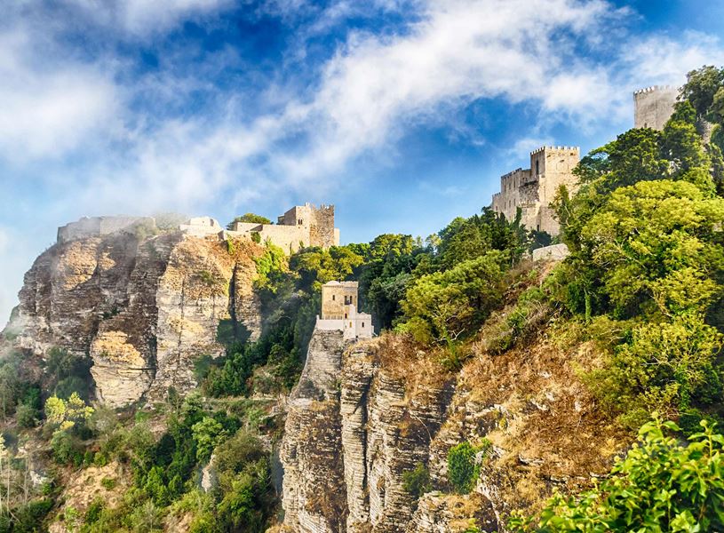 Medieval castles of Erice perched on rocky cliffs surrounded by greenery