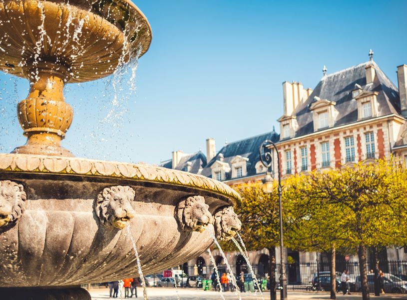 Ornate fountain with lion heads in Marais District, Paris