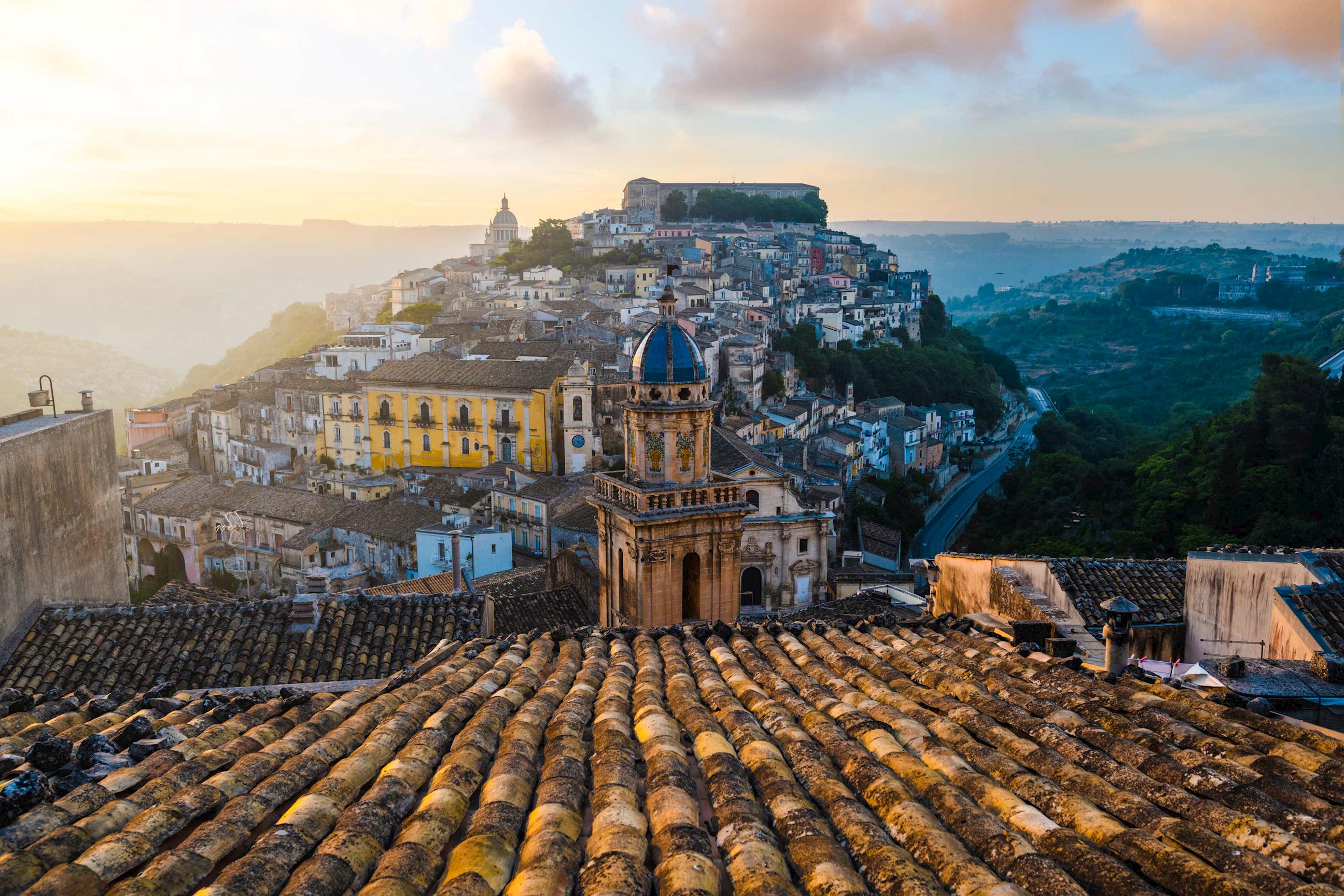 Sunset view of Ragusa Ibla in Sicily with historic rooftops and blue-domed church
