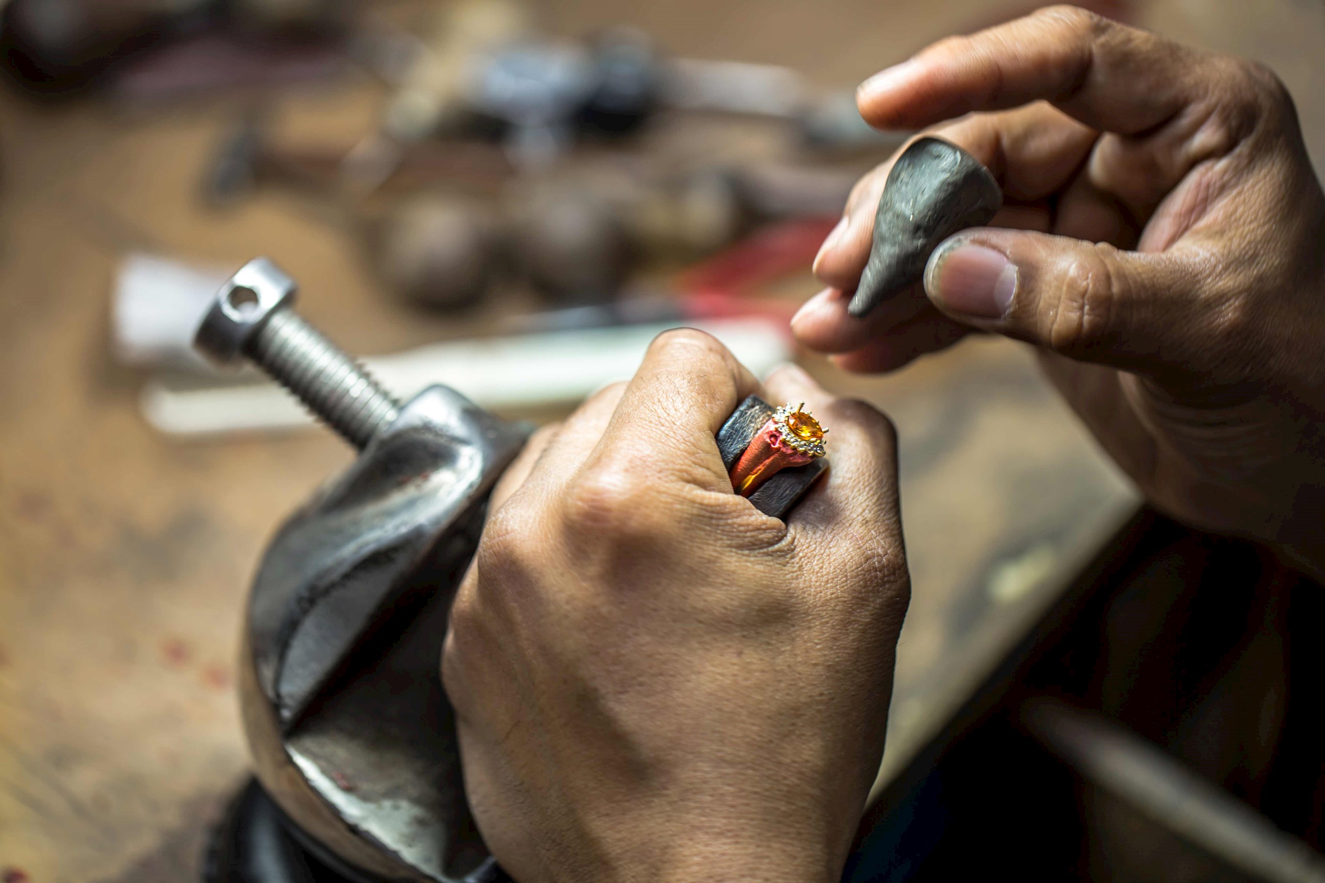 Close up of hands processing precious stones while making amulet, Sukhothai, Thailand