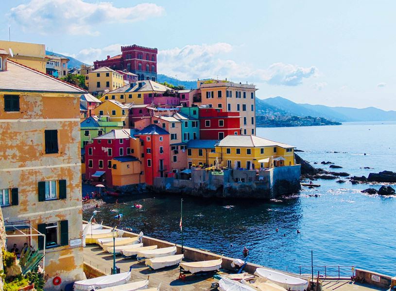Colorful seaside buildings in Boccadasse overlooking rocky coastline and blue sea