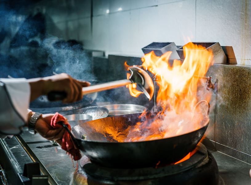 Person dressed as chef presenting Cambodian dishes at SPOONS Cafe, Siem Reap