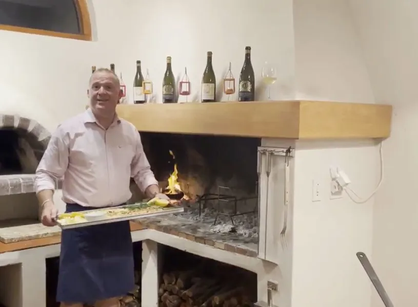 Stefan Hermanus holding tray of food by chimney, Hermanus, South Africa