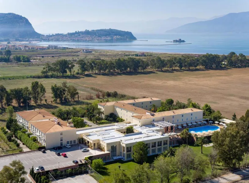 Aerial view of Hotel Amalia buildings surrounded by fields near coastline, Nafplio, Greece