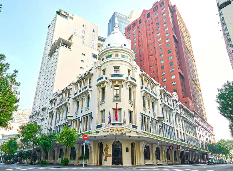 Grand Hotel Saigon exterior view with trees in background, Ho Chi Minh, Vietnam