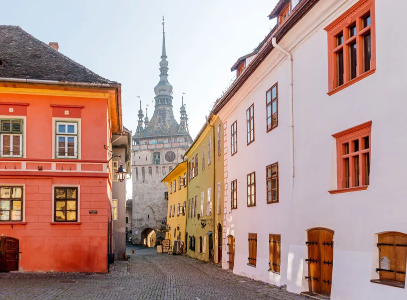 Colorful cobblestone street in Sighișoara leading to historic Clock Tower