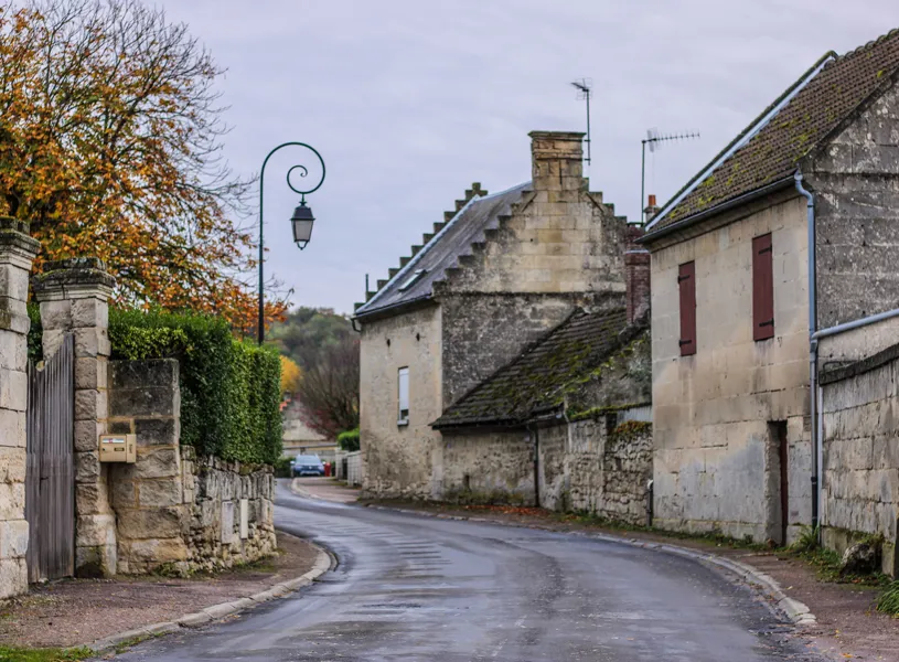 Stone village street with autumn trees and shuttered buildings
