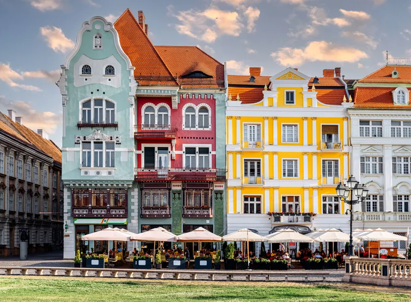 Colourful historic buildings with outdoor cafés in Union Square, Timișoara, Romania
