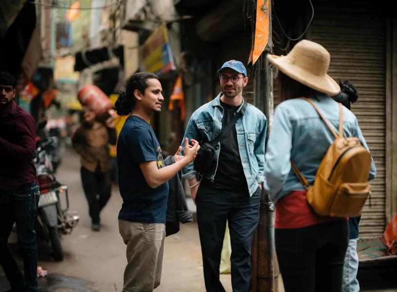 Guide showing travellers around on a city walking tour with the Salaam Baalak Trust, Delhi, India
