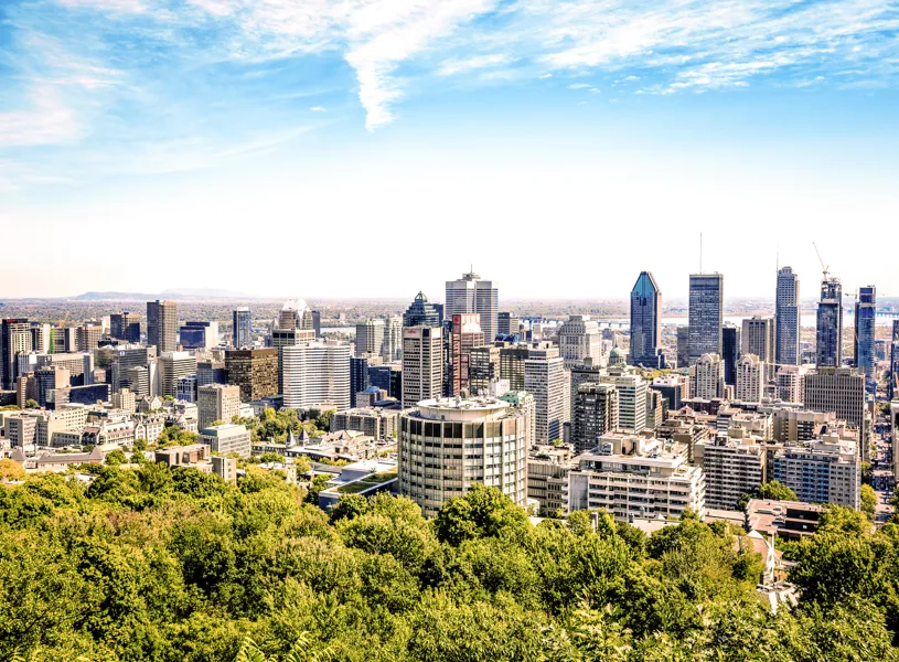 View of Montreal Skyline with green trees and blue skies