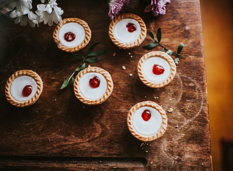 Cherry Bakewells on table with flowers in Bakewell, England