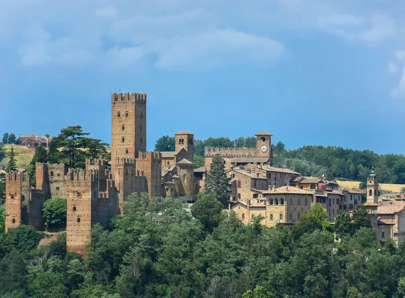 Medieval castle complex in Emilia-Romagna surrounded by trees