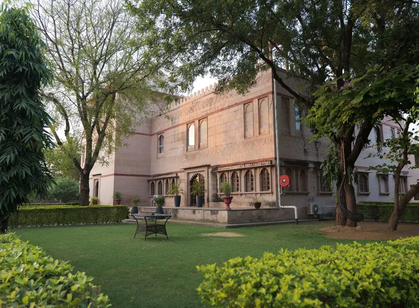 View of a lawn and the Shergarh Resort, Ranthambore, India