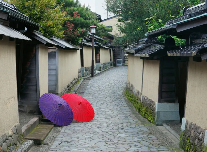 Bright umbrellas on paved walkway in Kanazawa Nagamachi Samurai District, Kanazawa, Japan