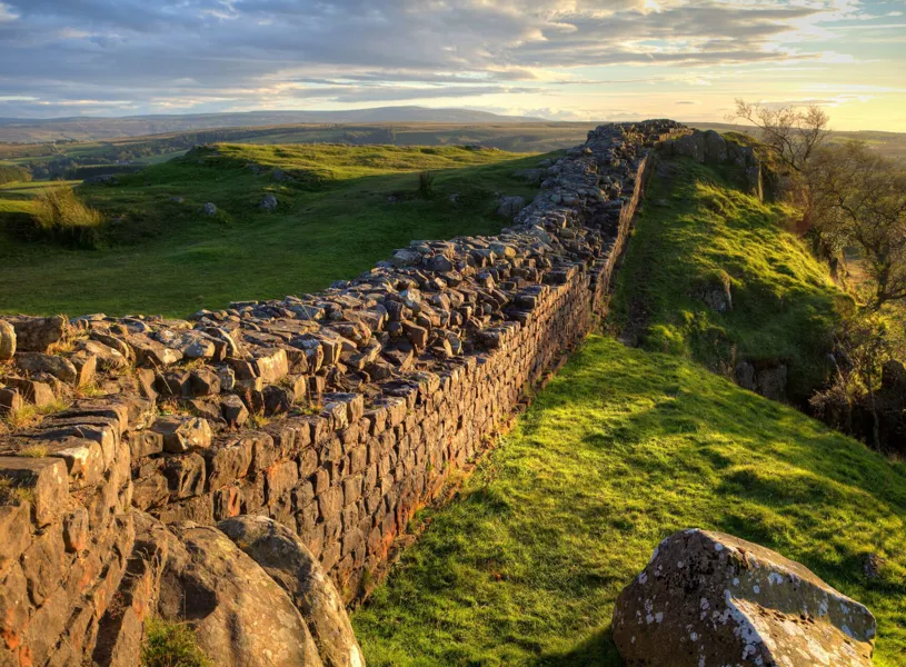 Hadrian's wall stretching across grassy hills in Durham, England