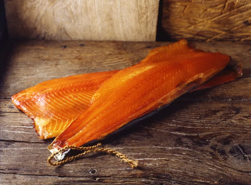 Two fillets of smoked salmon on rustic wooden surface