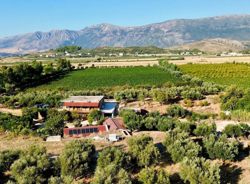 Aerial view Dukat of farm nestled in greenery on a sunny day, Vlorë, Albania