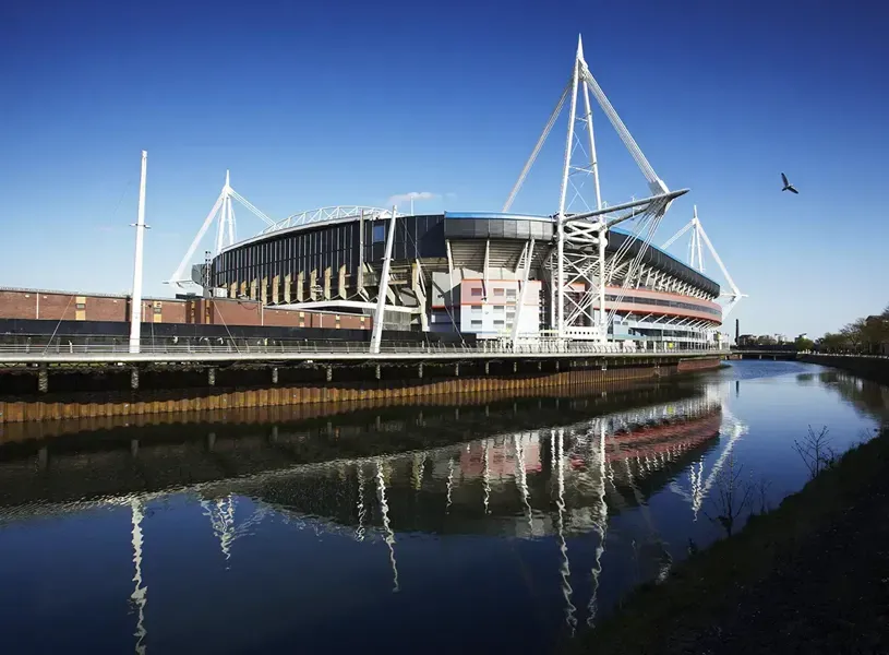 Principality Stadium reflected in bluew water on a clear day,  Cardiff, Wales
