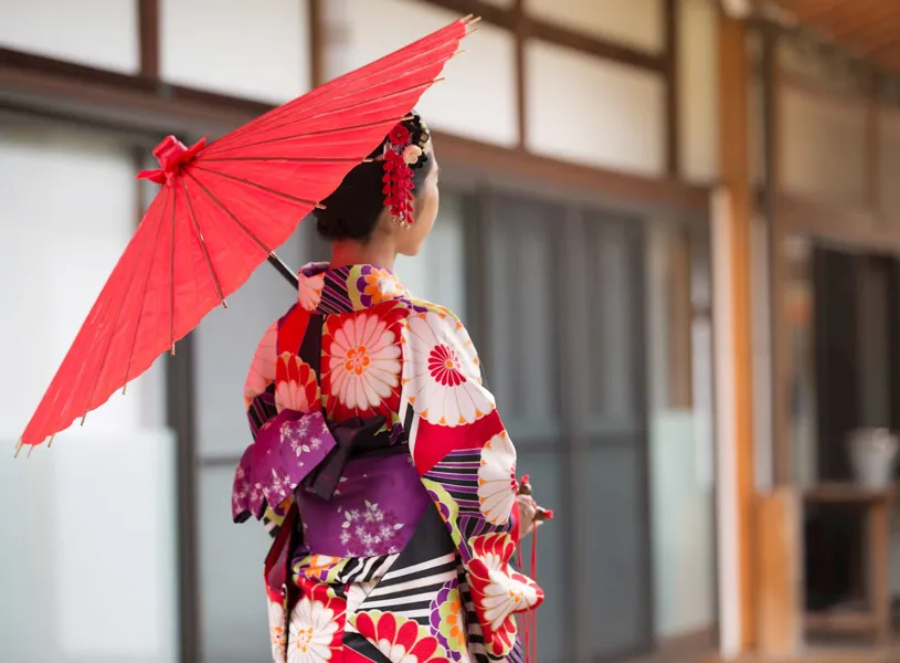 Woman in kimono holding red umbrella at Hyakumanben Chionji Temple, Kyoto