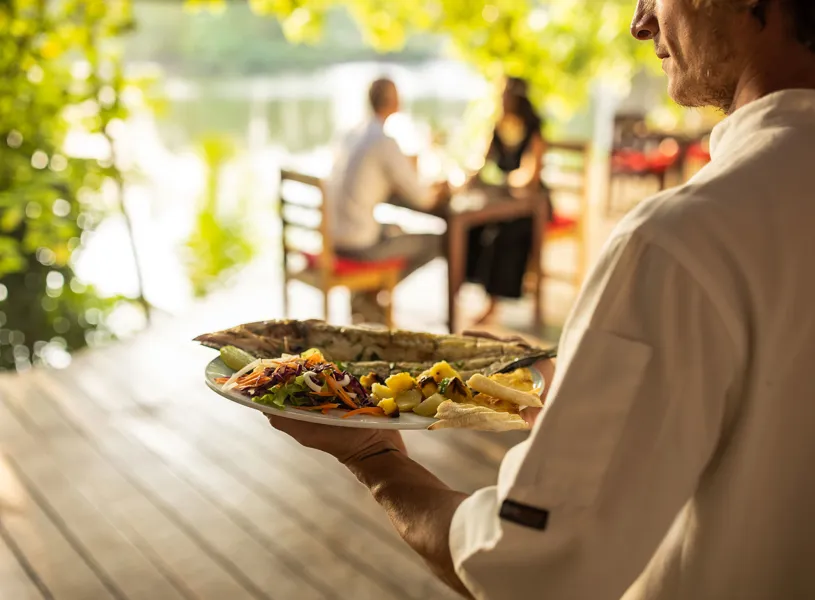 Waiter Carrying Seafood By Lake