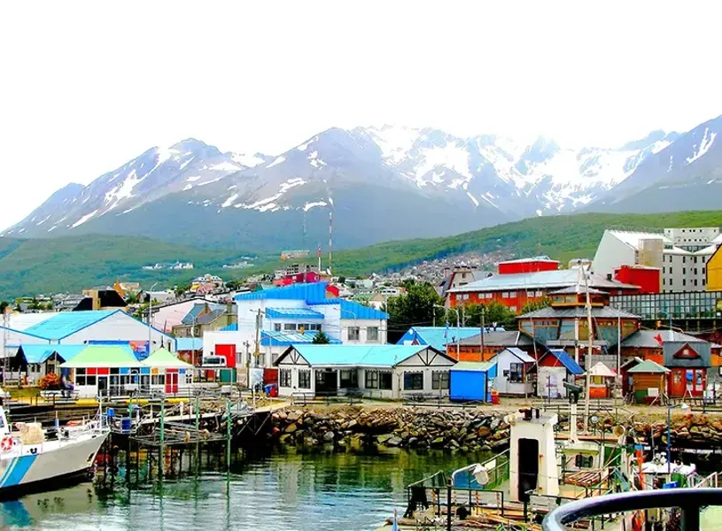 Looking across a harbour at the multi coloured houses in Ushuaia Argentina