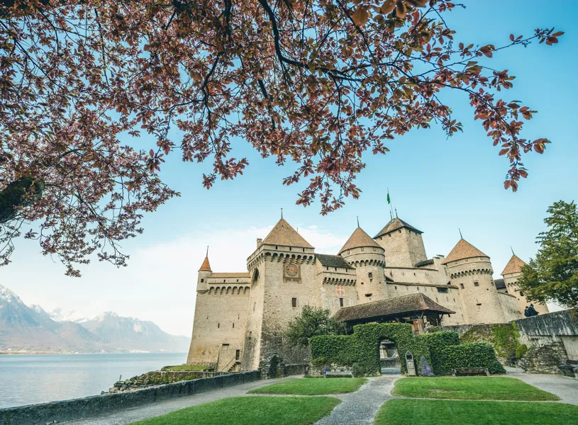 Chillon Castle by Lake Geneva with Alps and foliage in Switzerland